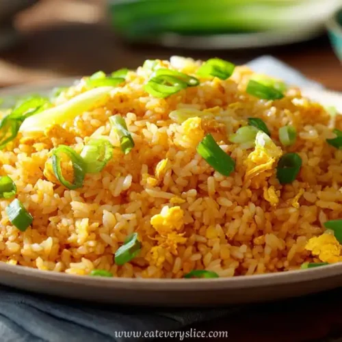 Plate of golden garlic fried rice with scallions, fluffy egg, and crispy edges
