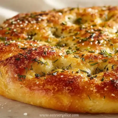 Golden garlic parmesan focaccia bread topped with herbs and sea salt