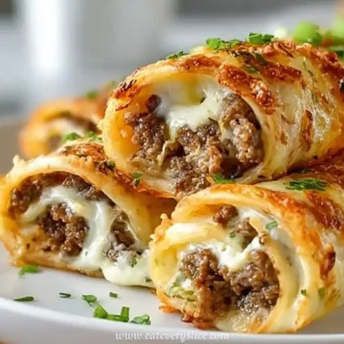 Cheesy keto Philly cheesesteak roll ups with ground beef and melted mozzarella, served golden and crispy