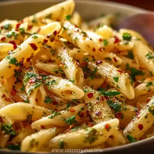 Penne pasta with garlic olive oil sauce, garnished with chili flakes and parsley