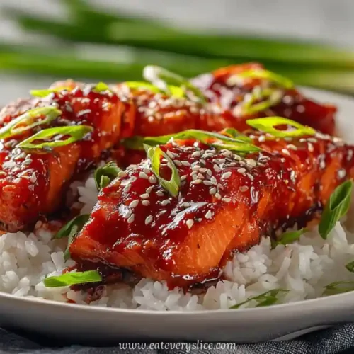 sweet and spicy glazed salmon fillets on white rice with green onion garnish
