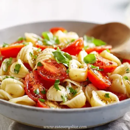 Close-up of bruschetta pasta salad with cherry tomatoes, basil, and orecchiette pasta