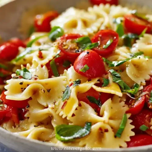 Fresh farfalle pasta salad with cherry tomatoes, basil, and olive oil in a rustic bowl