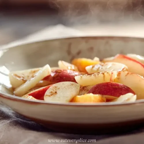 warm apple and citrus fruit bowl with cinnamon served in ceramic dish on rustic table