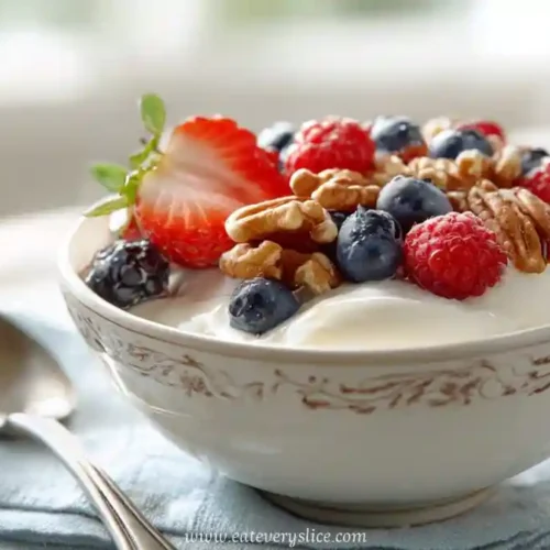 Greek yogurt breakfast bowl with fresh berries and walnuts served in a patterned dish on a napkin