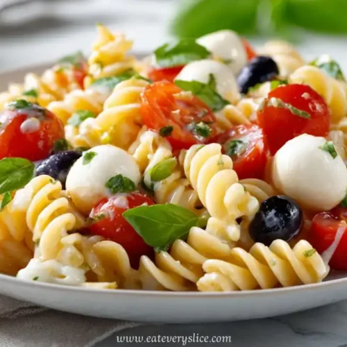 caprese pasta salad with mozzarella cherry tomatoes basil and olives on plate