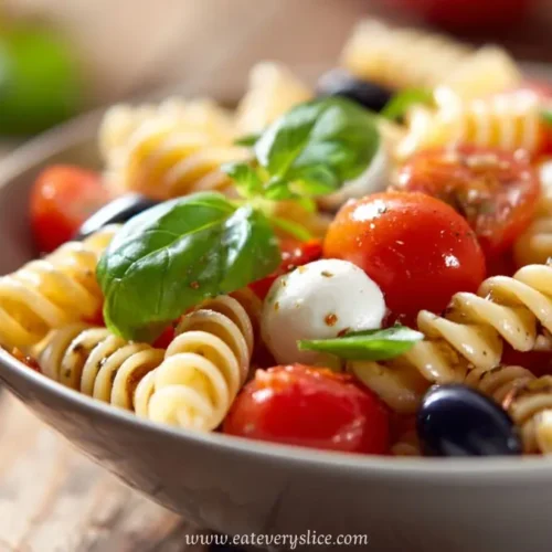 caprese pasta salad with cherry tomatoes mozzarella olives basil and herbs in bowl