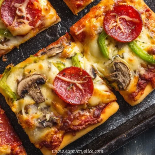 pepperoni flatbread pizza with mushrooms green peppers and melted cheese on baking tray
