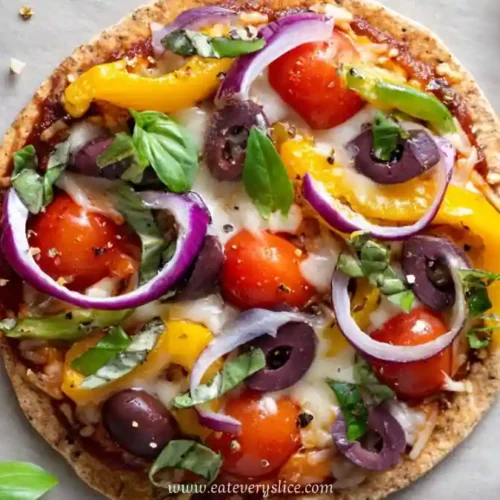 veggie pizza with cherry tomatoes olives bell peppers red onion and basil on crispy crust
